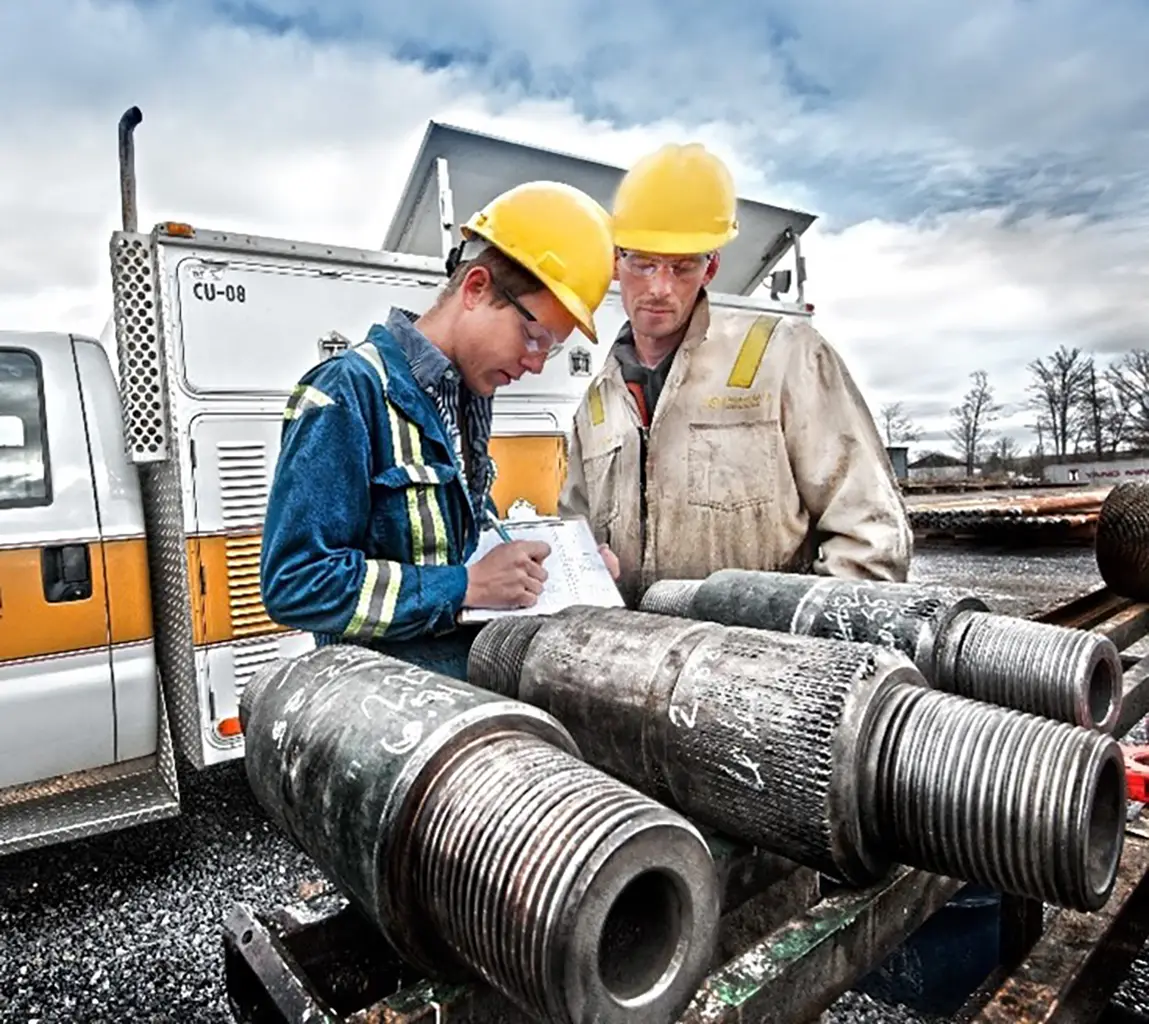 Force Inspection drill pipe services workers looking at pipe and paperwork